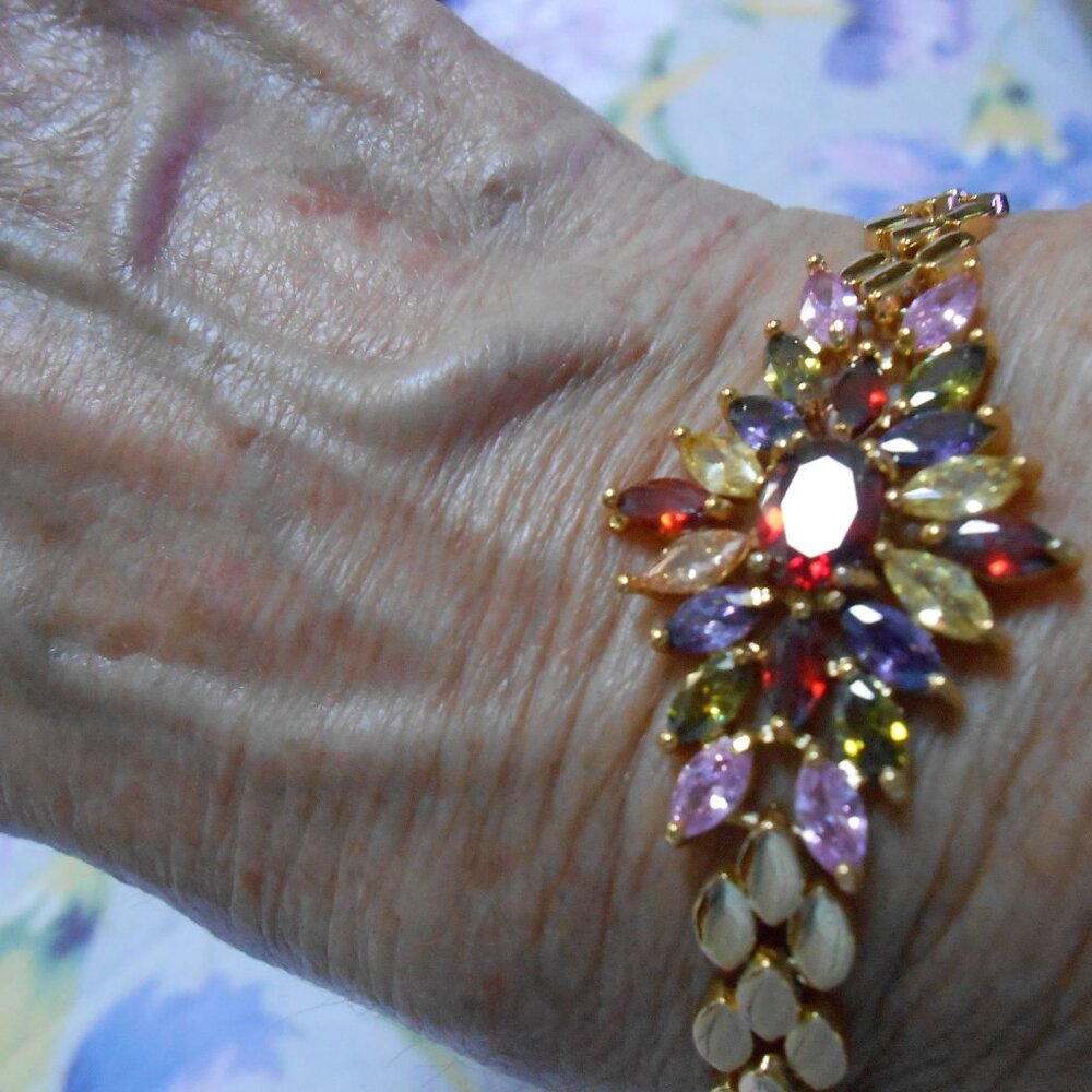Women’s NWOT gold and multicolored rhinestone starburst bracelet.